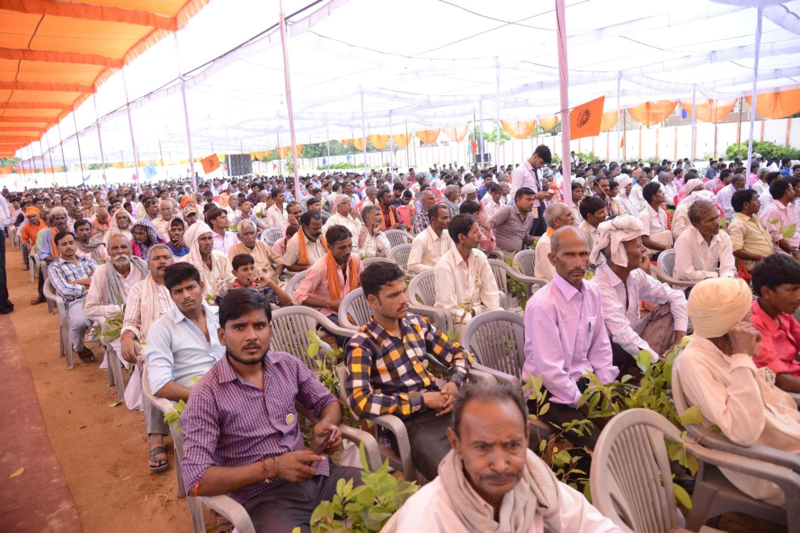 Farmers seated under the tent with their sapling packets at a 2019 camp